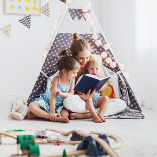 Moeder leest dochters voor in tent
